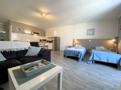 sala de estar con sofá y 2 camas en Les 5 Sources, en Vals-les-Bains