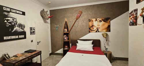 a bedroom with a bed and posters on the wall at Hotel Karthäuser Hof in Flörsheim