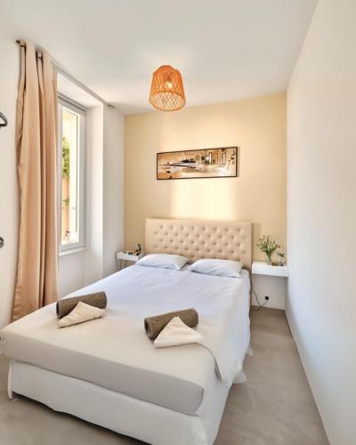 une chambre avec un grand lit blanc avec une fenêtre dans l'établissement FRGK Suquet 