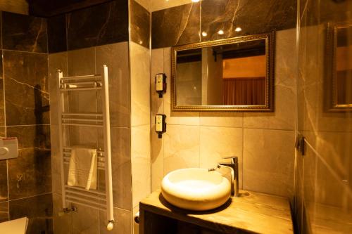 a bathroom with a sink and a toilet and a mirror at Lemon Cave Suites in Avanos