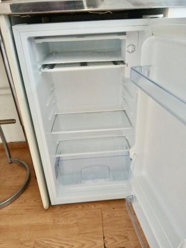 un réfrigérateur vide avec sa porte ouverte dans une cuisine dans l'établissement Studio Hyper Centre Quiet and Fully Equipped, à Grenoble