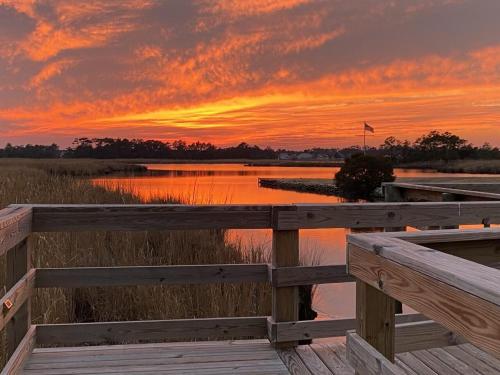 a sunset over a body of water with a wooden dock at Cambridge Reserve at Bermuda Bay by KEES Vacations in Kill Devil Hills