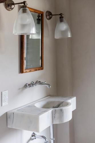 a bathroom with a white sink and two lights at The Bend in Phoenicia
