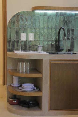 a kitchen with a sink and a counter with plates at Minimalist Verde Chapu in Guadalajara