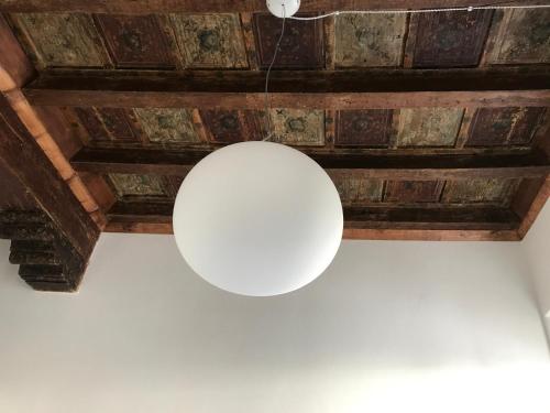 マントヴァにあるCasa San Matteoの木製天井から吊るされる白い光
