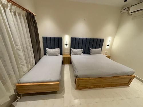 two twin beds in a room withthritisthritisthritisthritisthritisthritisthritisbestosbestos at The Cocoon in Dehradun