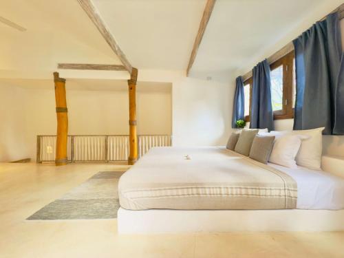 a large white bed in a room with blue curtains at Soul Dream Bonita in Las Terrenas