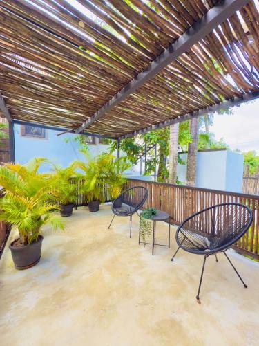 a patio with two chairs and potted plants at Soul Dream Bonita in Las Terrenas