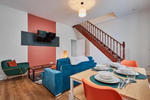 a living room with a table and a blue couch at Relaxing 3-Bedroom Home Near the Beach in Seaham