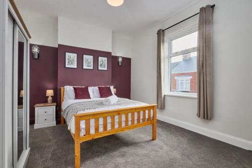 SeahamにあるRelaxing 3-Bedroom Home Near the Beachのベッドルーム1室(木製ベッド1台、窓付)