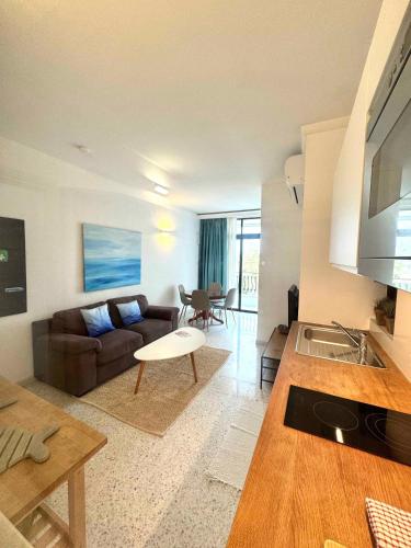 a living room with a couch and a table at Sands Apartments in St Paul's Bay