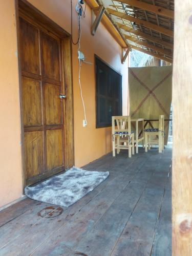 a porch with a door and a table and chairs at Casa Isla Paraíso in Mazunte