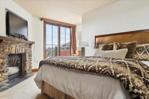 ein Schlafzimmer mit großem Bett und Kamin in der Unterkunft Purgatory Lodge Unit 505 in Durango Mountain Resort