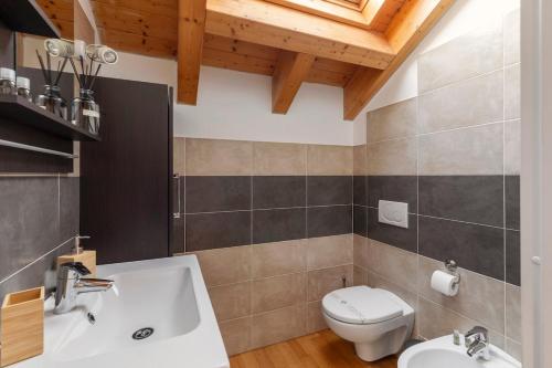 a bathroom with a white toilet and a sink at Attico Fiera Milano in Rho