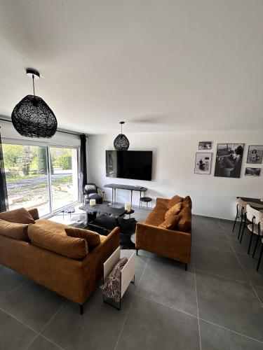 un salon avec deux canapés et une table dans l'établissement L'Opale - Le Bercail, à Les Attaques