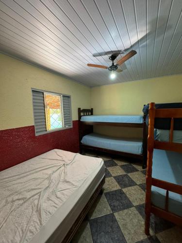 a bedroom with two bunk beds and a ceiling fan at Chácara Leão Dourado in Pôrto Feliz