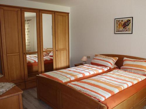 a bedroom with a large bed and a cabinet at Ferienwohnungen Im Försterhaus in Lonsee