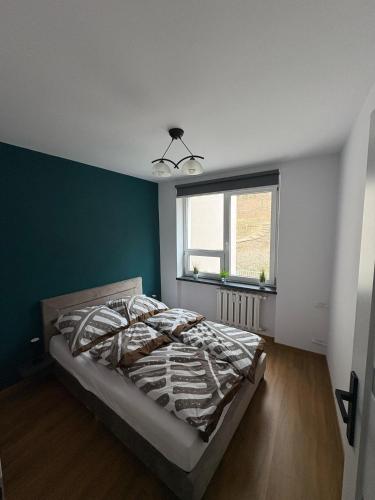 a bedroom with a bed and a green wall at Kościuszki in Sanok