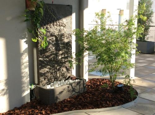 a garden in front of a building with a tree at Les plages du Grand Vallen - Résidence Château Leenhardt in Le Grau-du-Roi