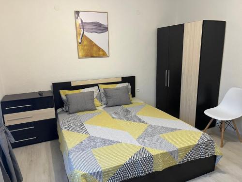 a bedroom with a bed and a cabinet and a chair at Positive Apartment in Petrich