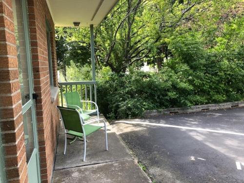 a green chair sitting on the porch of a house at Ludington Blue Spruce Inn in Ludington