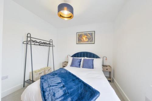 ein Schlafzimmer mit einem Bett mit einer blauen Decke darauf in der Unterkunft Luxury One Bedroom Apartment St Albans By Central Stays Short Lets & Serviced Accommodation With Free Parking in St Albans