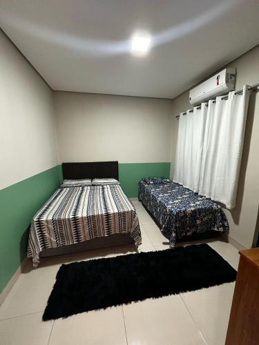 2 Betten in einem Zimmer mit Teppichen in der Unterkunft CASA 04 próximo ao Centro in Palmas