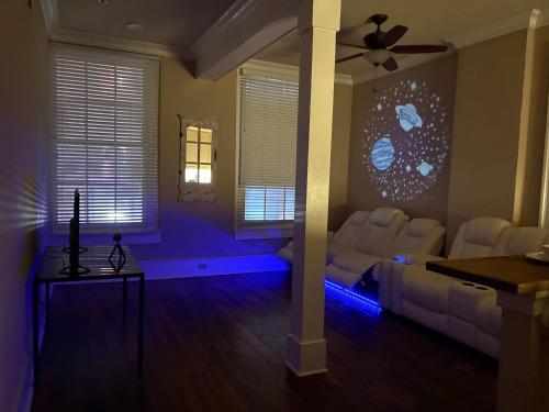 een woonkamer met witte stoelen en een plafondventilator bij 305 Decatur st in New Orleans