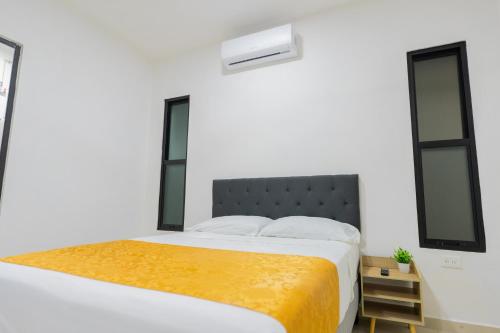 a bedroom with a bed and two windows at Peregrina 270 Departamentos in Motul de Felipe Carrillo Puerto