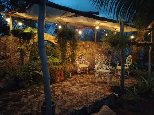 a patio with chairs and lights at night at Casa Quinta Luna in Homún