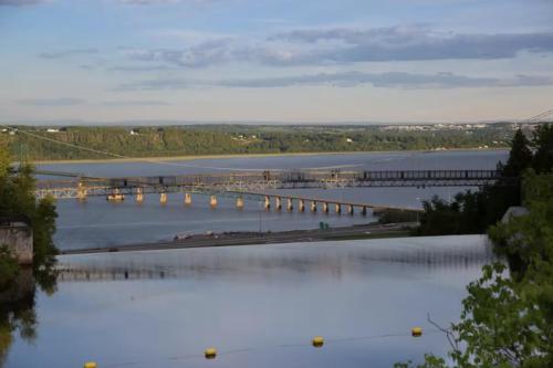 a large body of water with a bridge in the distance at INITIAL - MAITRE - Chutes-Montmorency in Boischâtel