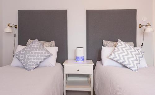 a bedroom with two beds and a side table with a candle at OrangeTreeHouses in Montijo