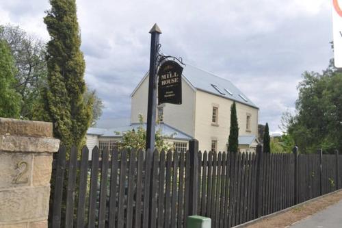 a white house with a fence and a sign in front at The Mill House Cottage in Richmond