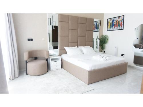 Un dormitorio con una cama grande y una silla. en Soco Apartment, en Lekki