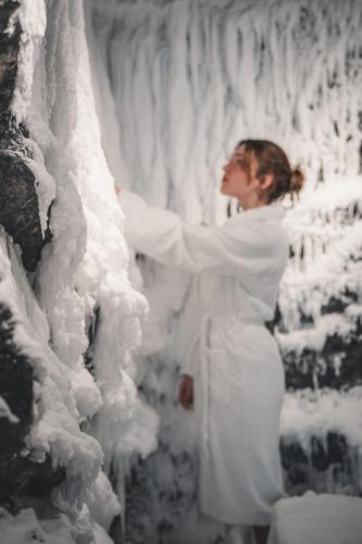 a woman is standing in front of an ice wall at Ferienwelt Kesselgrub Hotel in Altenmarkt-Zauchensee in Altenmarkt im Pongau