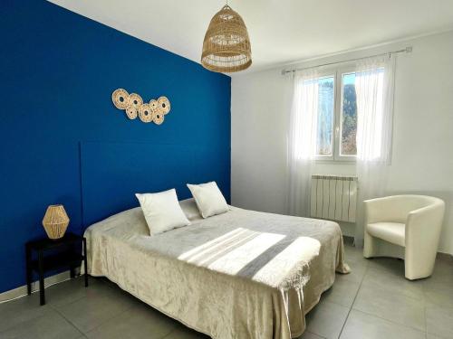 Un dormitorio azul con una cama y una silla. en Villa du Vallon, en Allemagne-en-Provence