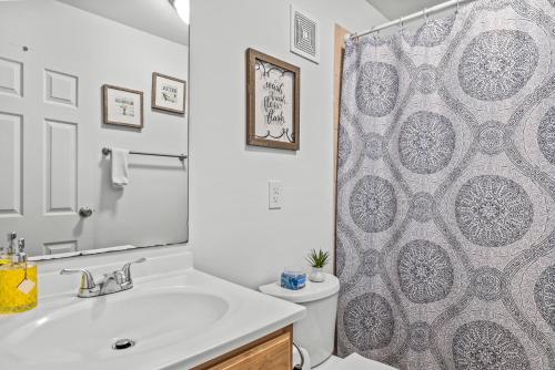 a bathroom with a sink and a shower curtain at Classic City Getaway at Stadium Village in Athens