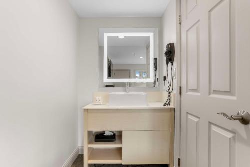 a bathroom with a sink and a mirror next to a door at Signature Inn Berkeley in Berkeley