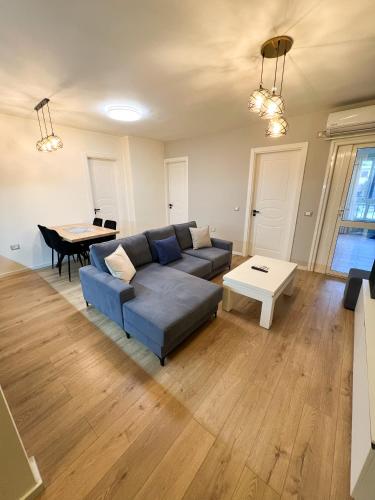 a living room with a blue couch and a table at Sea View Apartments in Durrës