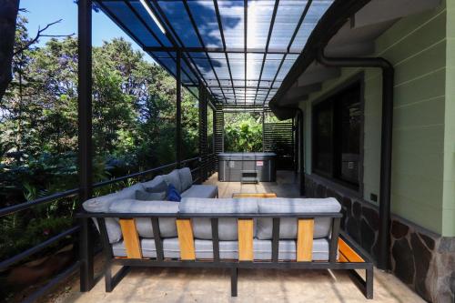 a screened in porch with a couch on a deck at Los Pinos Cabins & Reserve in Monteverde Costa Rica