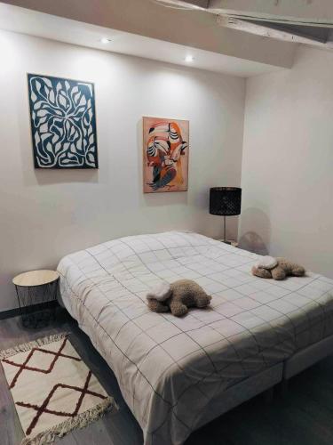 2 animaux farcis dormant sur un lit dans une pièce dans l'établissement Appartement Atypique, à Épinal