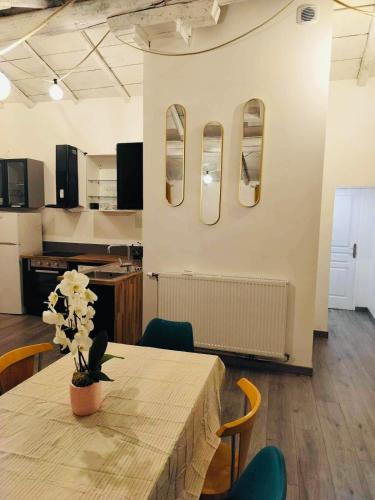 - une salle à manger avec une table et des fleurs dans l'établissement Appartement Atypique, à Épinal