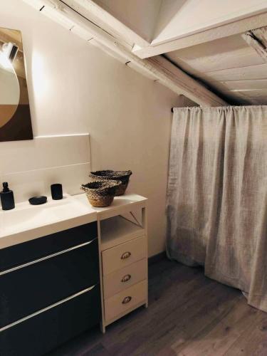 une salle de bain avec un lavabo et un rideau de douche dans l'établissement Appartement Atypique, à Épinal
