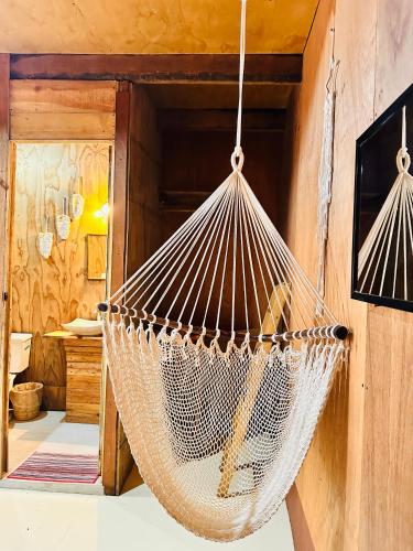 a hammock hanging from a wall in a room at Hotel Cabañas y Glamping Punta Surf in Brisas de Zicatela