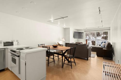 a kitchen and living room with a table and a stove at Southpoint 2D, Prime Access to Aspen Mountain, 2 BED - 2 BATH with Stunning Mountain Views in Aspen