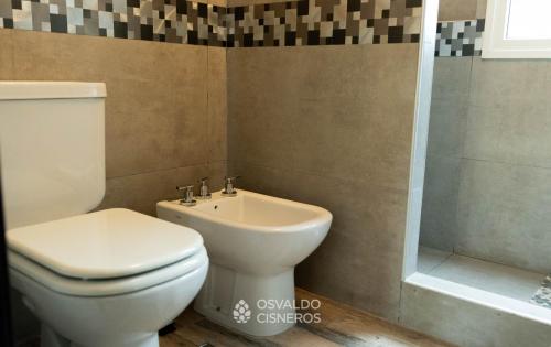ein Badezimmer mit Toilette, Waschbecken und Dusche in der Unterkunft Los Patitos in Mar de las Pampas