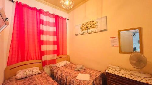 a bedroom with two twin beds and a red curtain at Ala do castelo hotel in Lagos