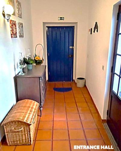 a hallway with a blue door and a bench at Prédio do Castelo in Caloura