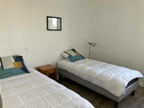 - une chambre avec 2 lits et une table avec un miroir dans l'établissement Gite 6 pers au Temple à 15 min du parc PuyduFou, à Mauléon