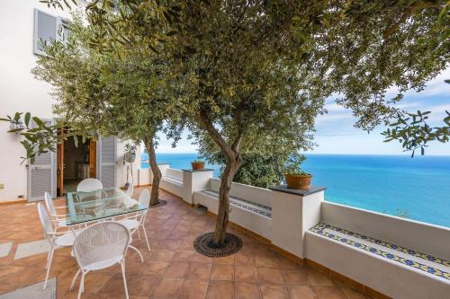 a patio with a table and chairs and the ocean at Villa Antonella Amalfi Coast in Praiano